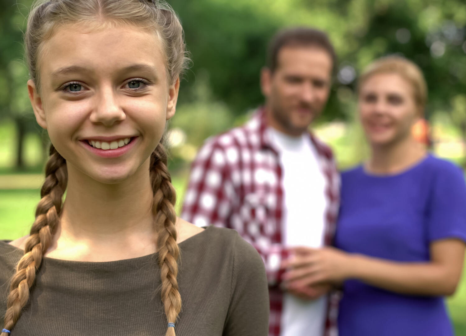 proud autistic teenager with parents in background